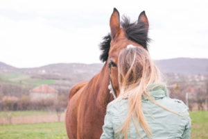 Girl cuddling with her horse