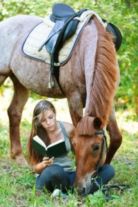 Girl reading with her horse