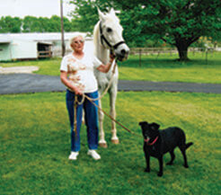 Barbara with Asti the Arabian and Blackie the dog.